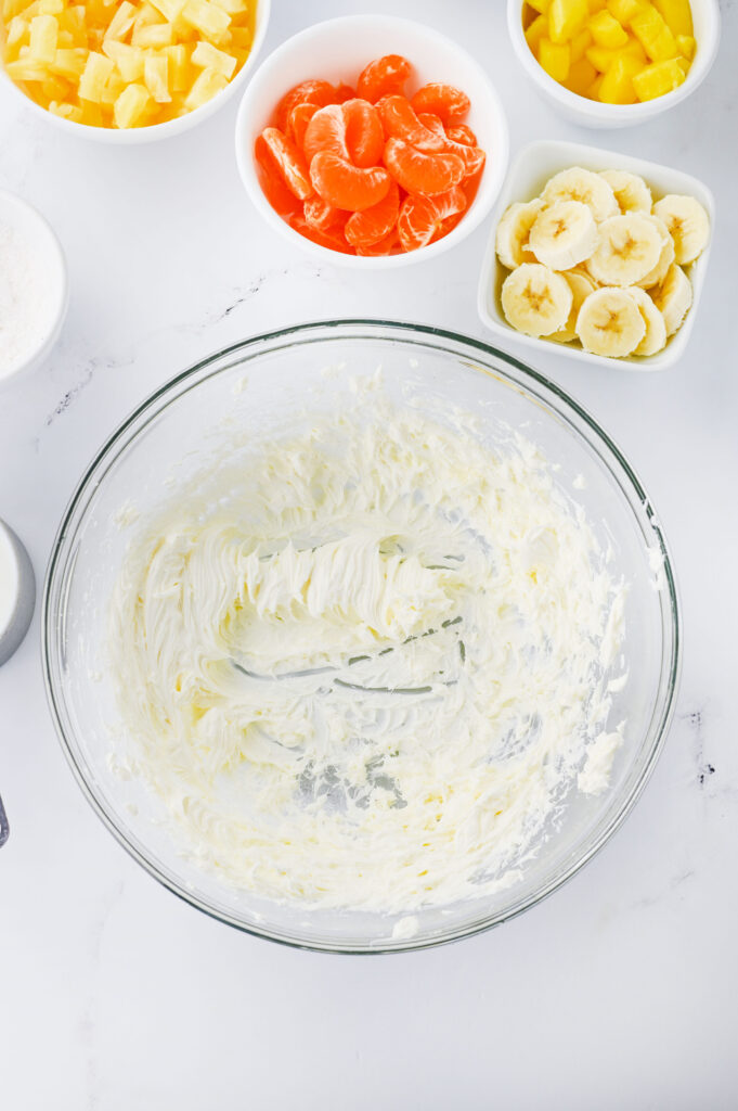 Creme de queijo sendo chicoteado em uma tigela de vidro.