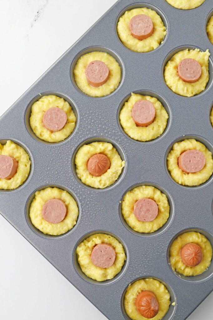 sliced hot dogs place into the center of cornbread batter.