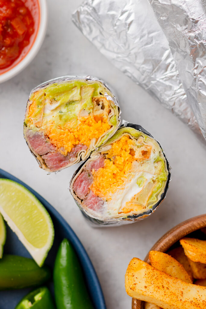a burrito cut in half with ingredients showing.