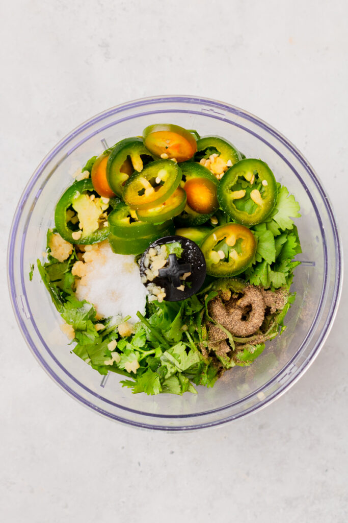 fresh ingredients added to a food processor making a marinade.
