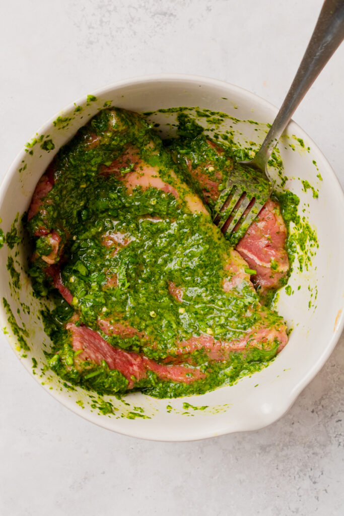 steak and marinade combined in a mixing bowl.