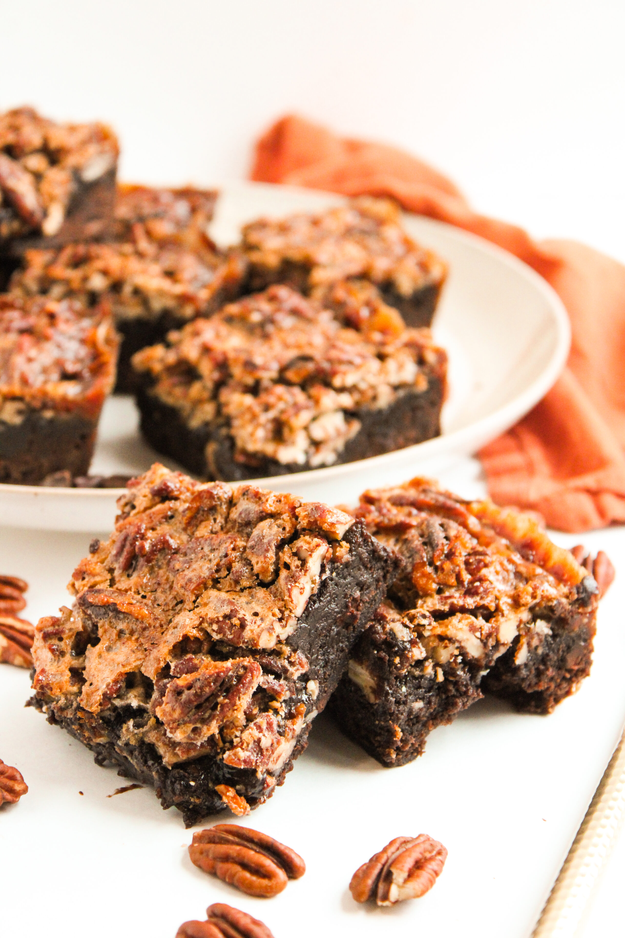 pecan pie brownies sliced on a white plate and ready to serve.