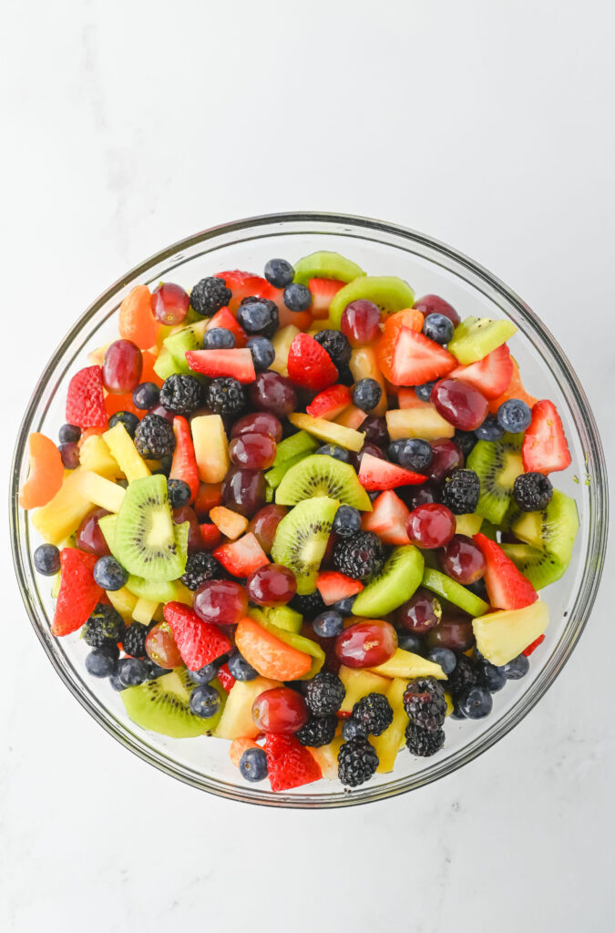 honey lime dressing over fresh fruit in a bowl.
