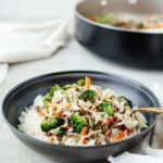 egg roll in a bowl served over white rice in a black bowl.