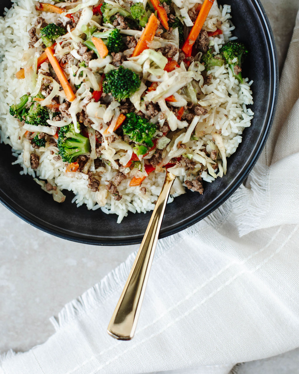 One pan egg roll in a bowl with broccoli and hoisin sauce garnish