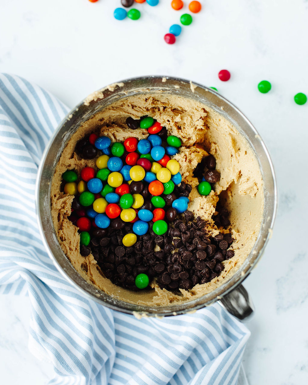 chocolate chips and m & m's folded into cookie dough.