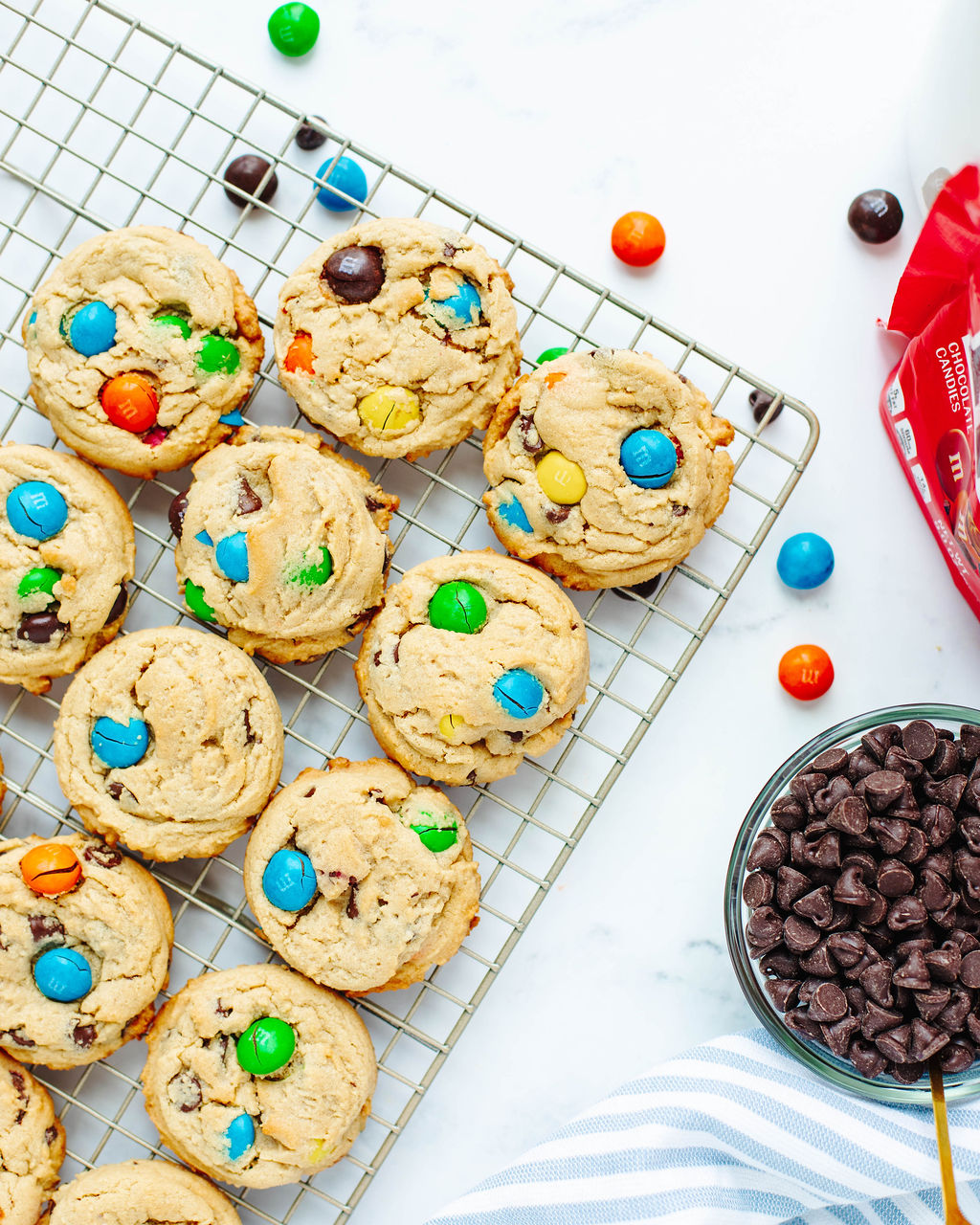Freshly baked peanut butter M&M cookies cooling on a wire rack.