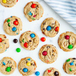 peanut butter m&m cookies on a parchment lined cookie sheet.
