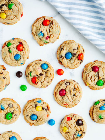 peanut butter m&m cookies on a parchment lined cookie sheet.
