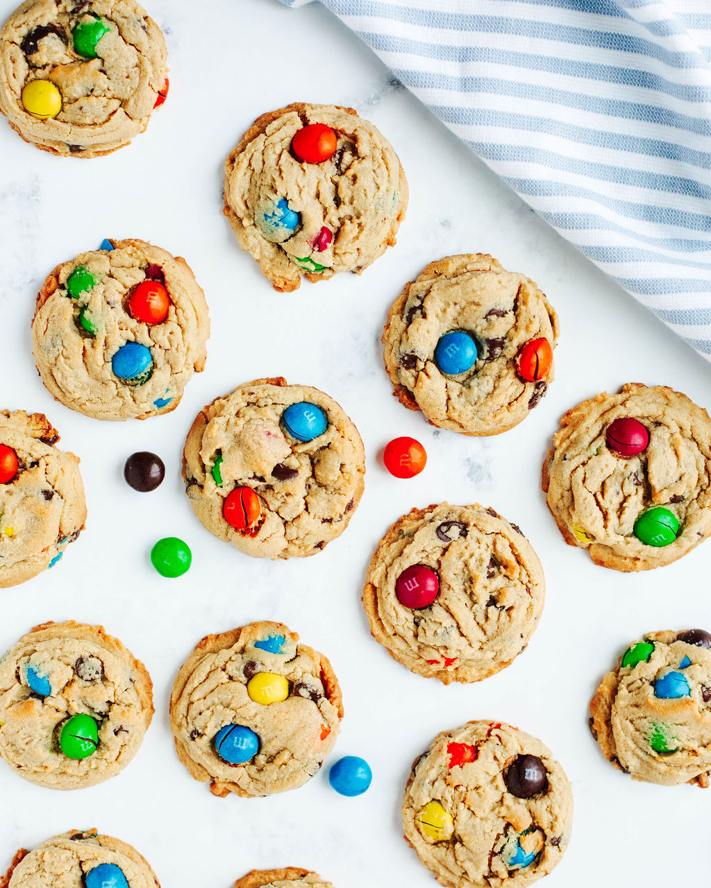 Close-up of peanut butter cookies loaded with colorful peanut butter M&Ms and mini chocolate chips.
