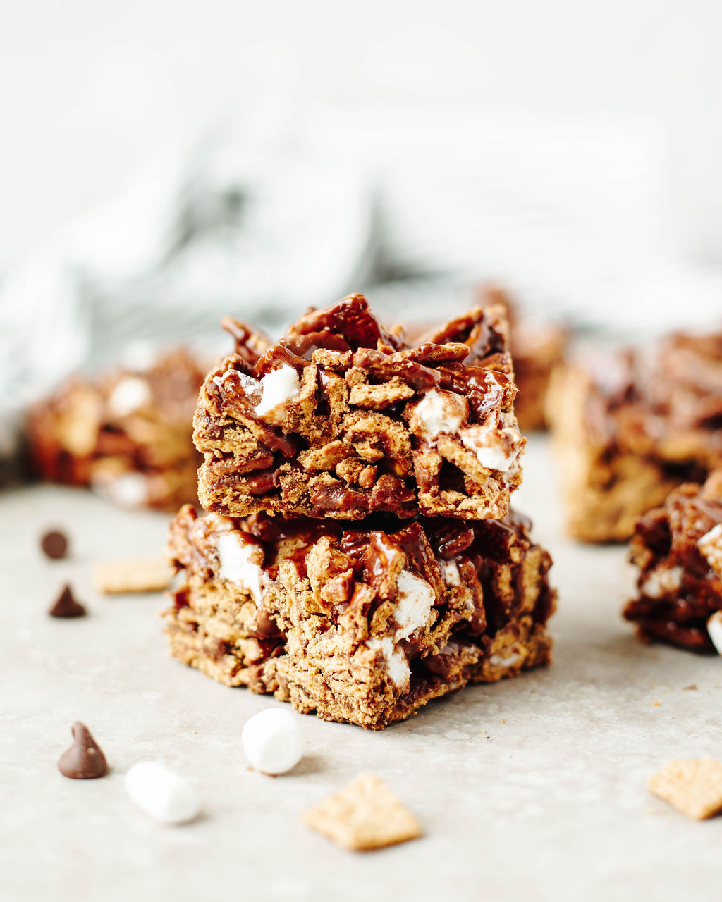 Golden Grahams s’mores bars stacked on a cutting board.