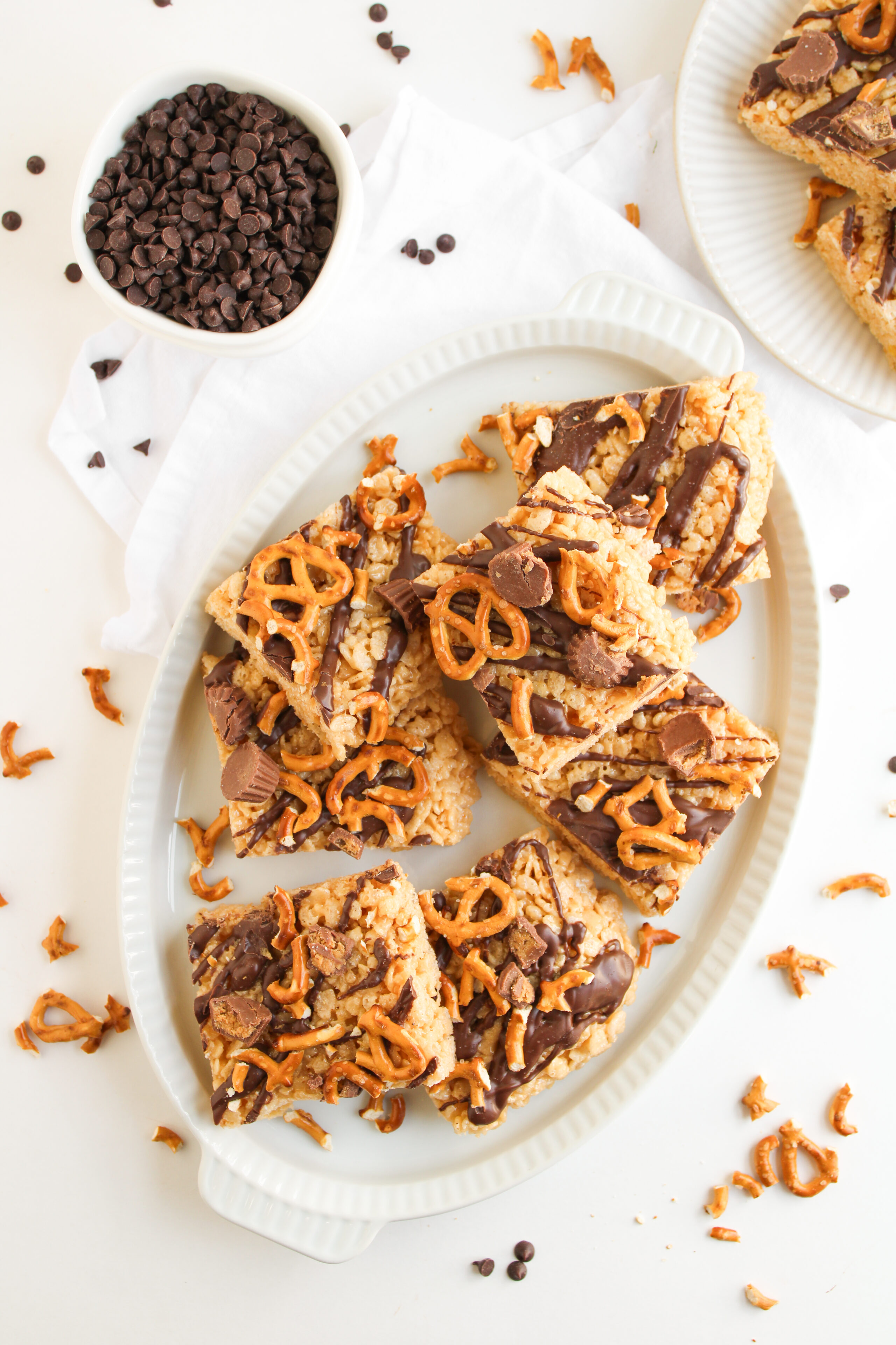 Chocolate peanut butter rice krispie treats cut into squares on a white plate.