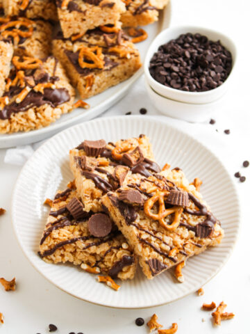 pieces of chocolate peanut butter rice krispie treats on a white plate with chocolate chips.