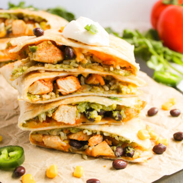 stacked chicken quesadillas on a cutting board ready to serve.