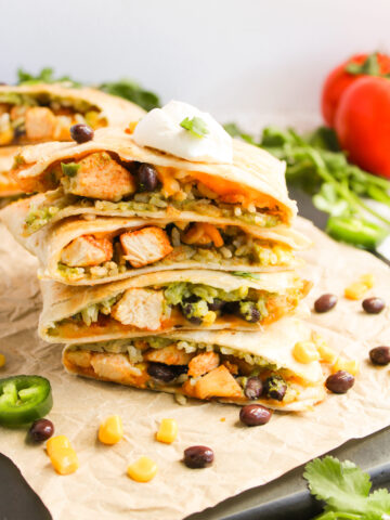 stacked chicken quesadillas on a cutting board ready to serve.