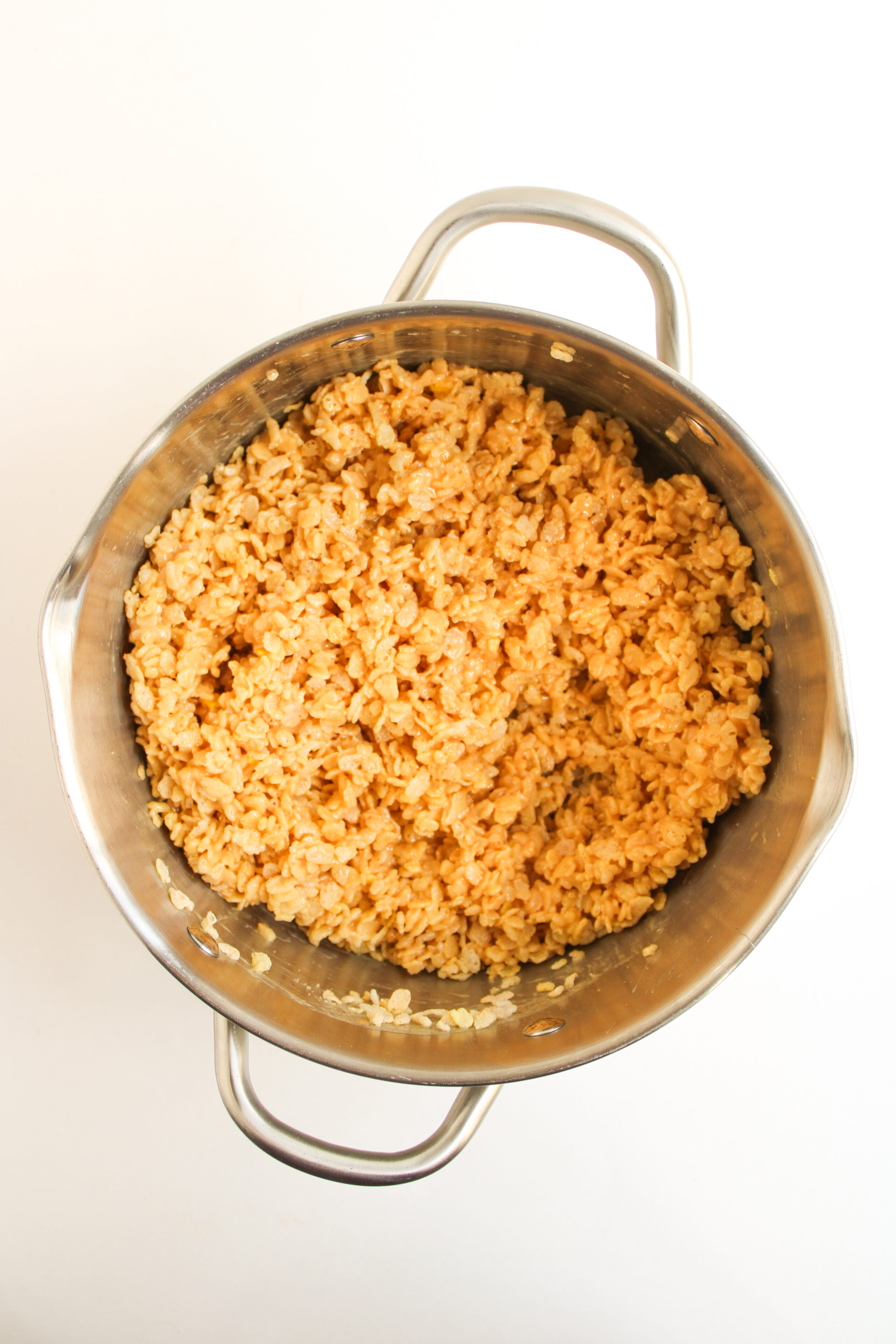 peanut butter, marshmallows, cereal, and vanilla combined in a sauce pan.