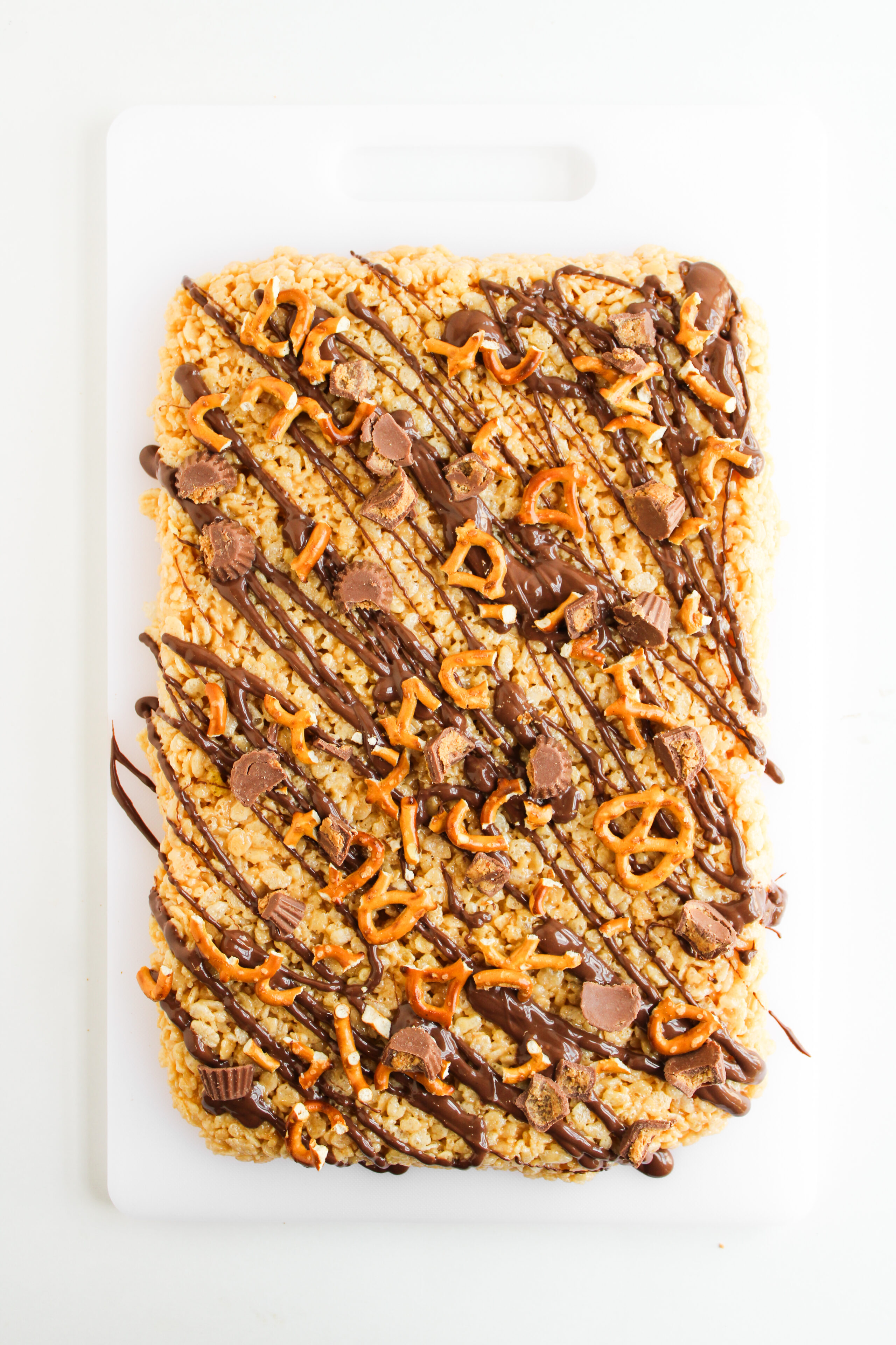 No bake chocolate peanut butter dessert topped with mini Reese’s and pretzels.