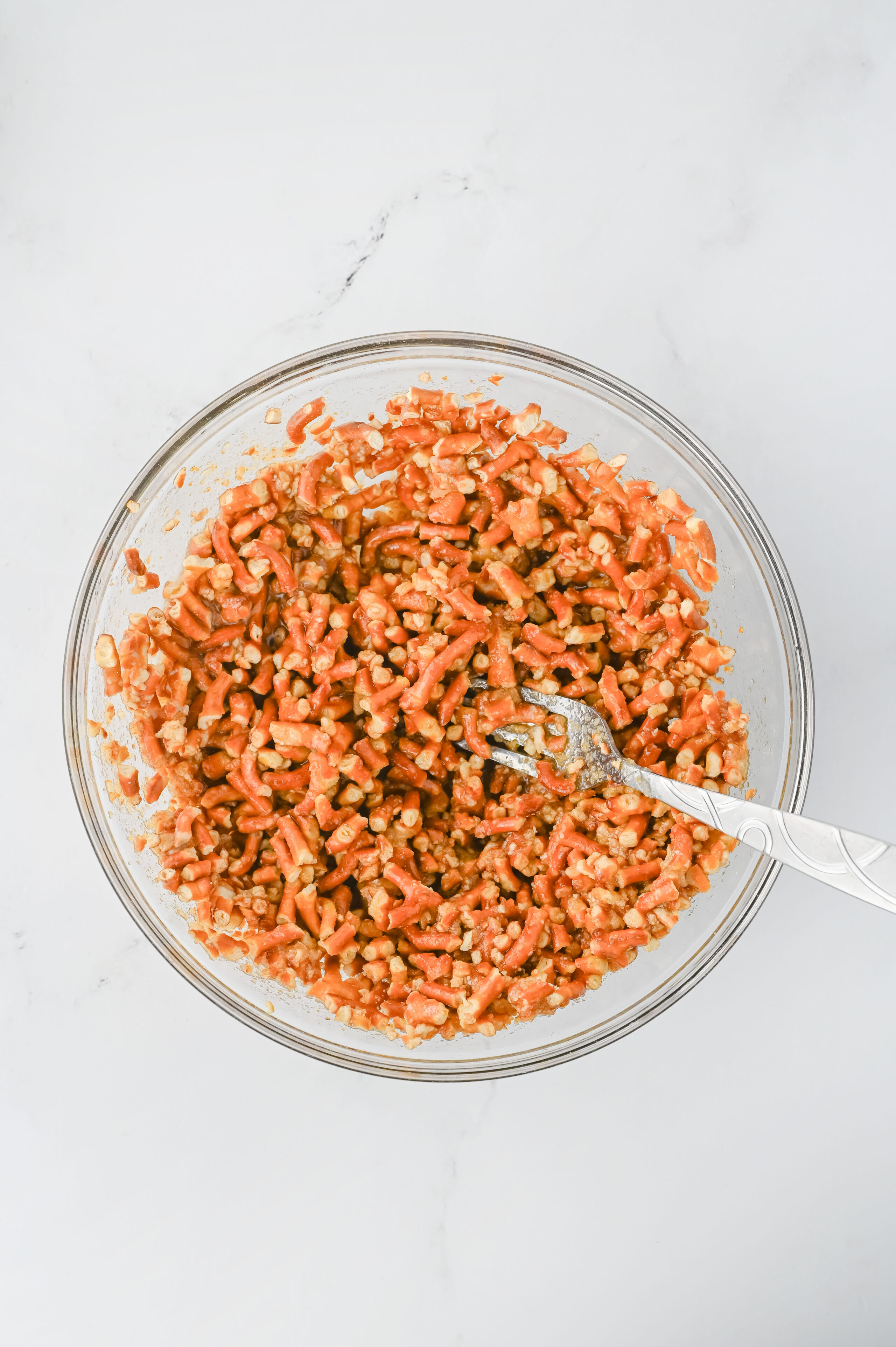 crushed pretzels in a glass mixing bowl.