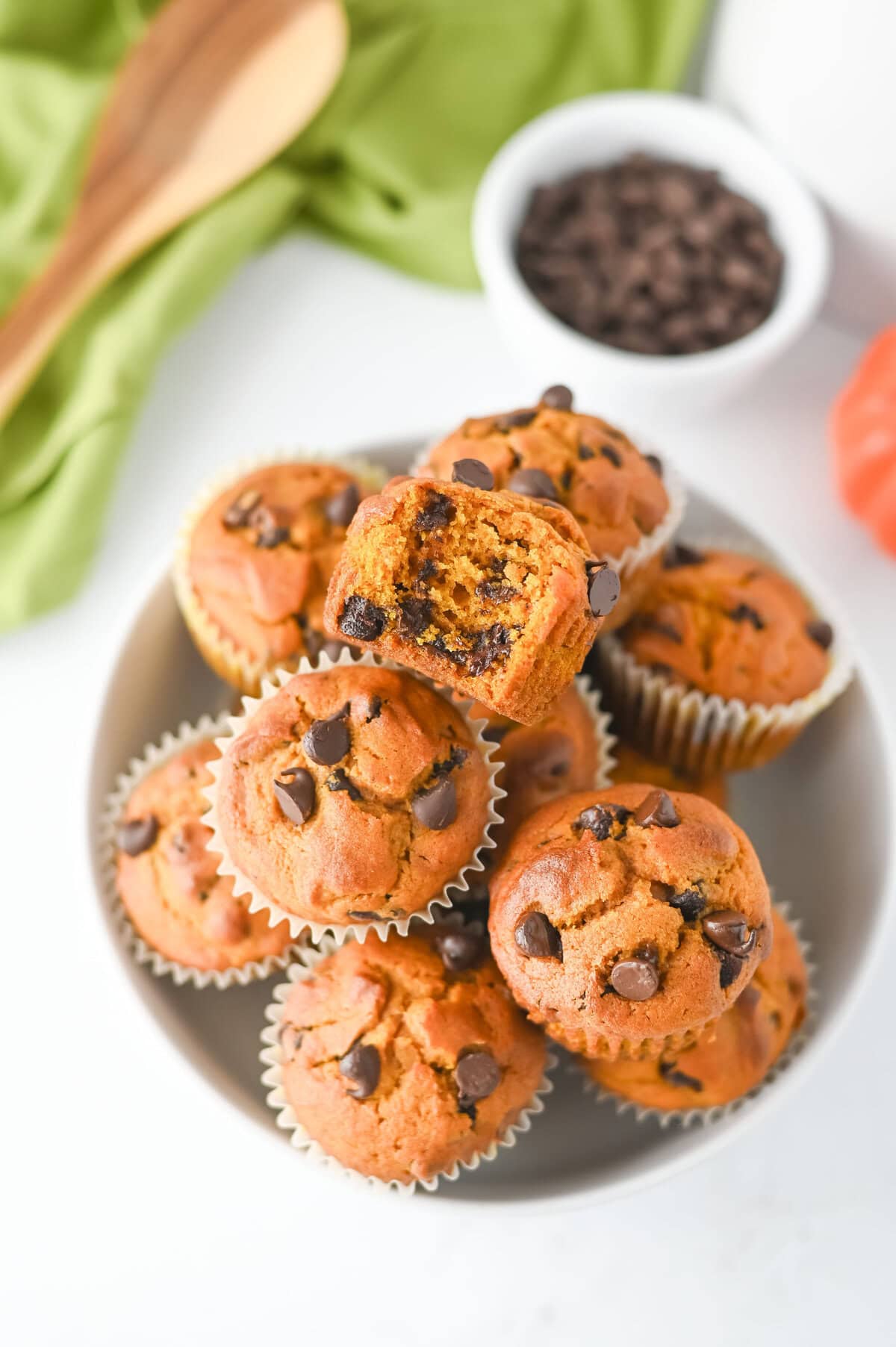 Homemade fall muffins with pumpkin puree and chocolate chips in a white bowl.