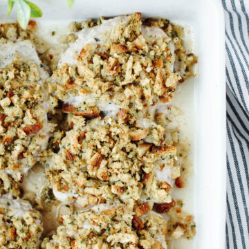 pork chops with stuffing in a white casserole dish.
