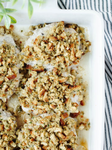 pork chops with stuffing in a white casserole dish.