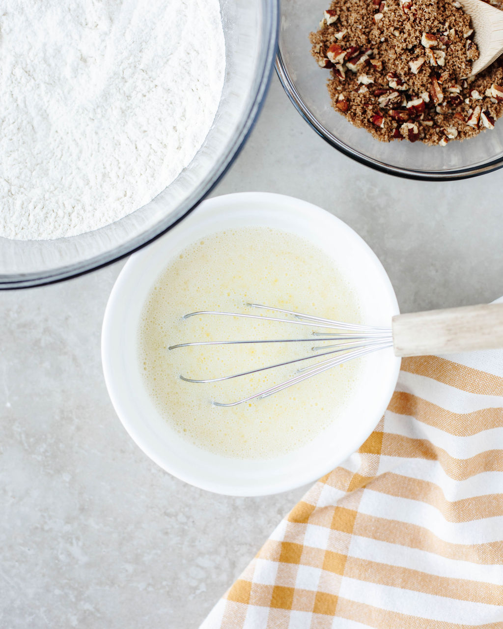Egg, milk, and oil being whisked in a separate bowl until smooth.