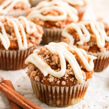 an up close look at pumpkin spice muffins drizzled with homemade cream cheese frosting.