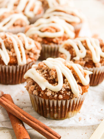 an up close look at pumpkin spice muffins drizzled with homemade cream cheese frosting.