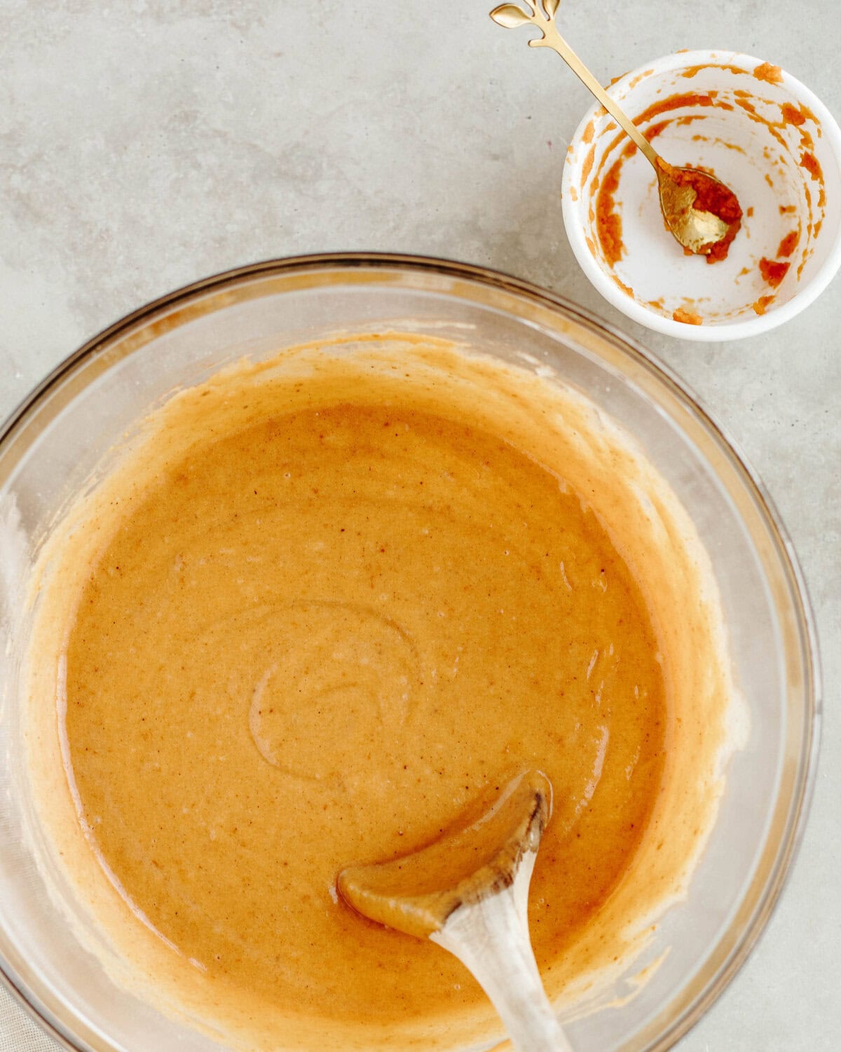 pumpkin puree added into the bread batter in a mixing bowl.