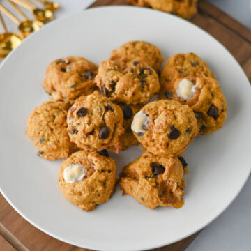 stacked pumpkin smores cookies on a white plate ready to serve.