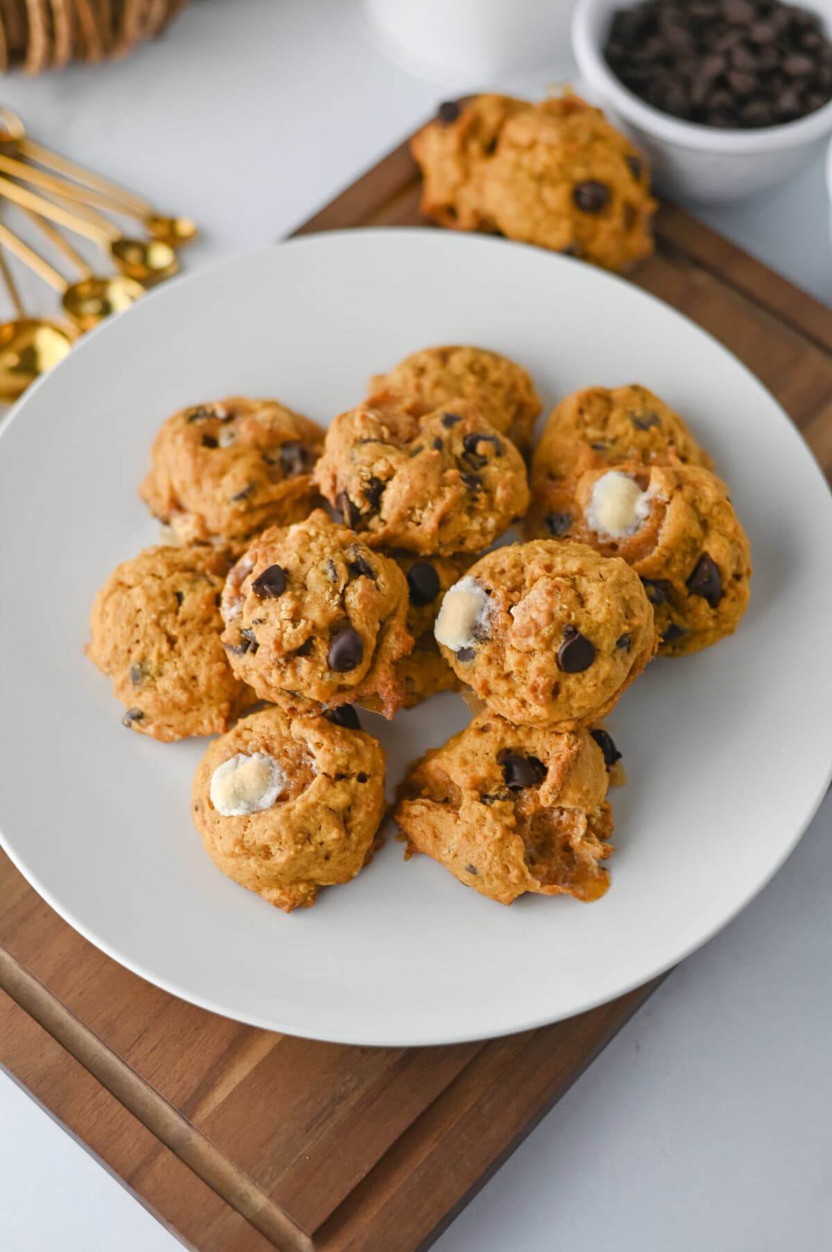 stacked pumpkin smores cookies on a white plate ready to serve.