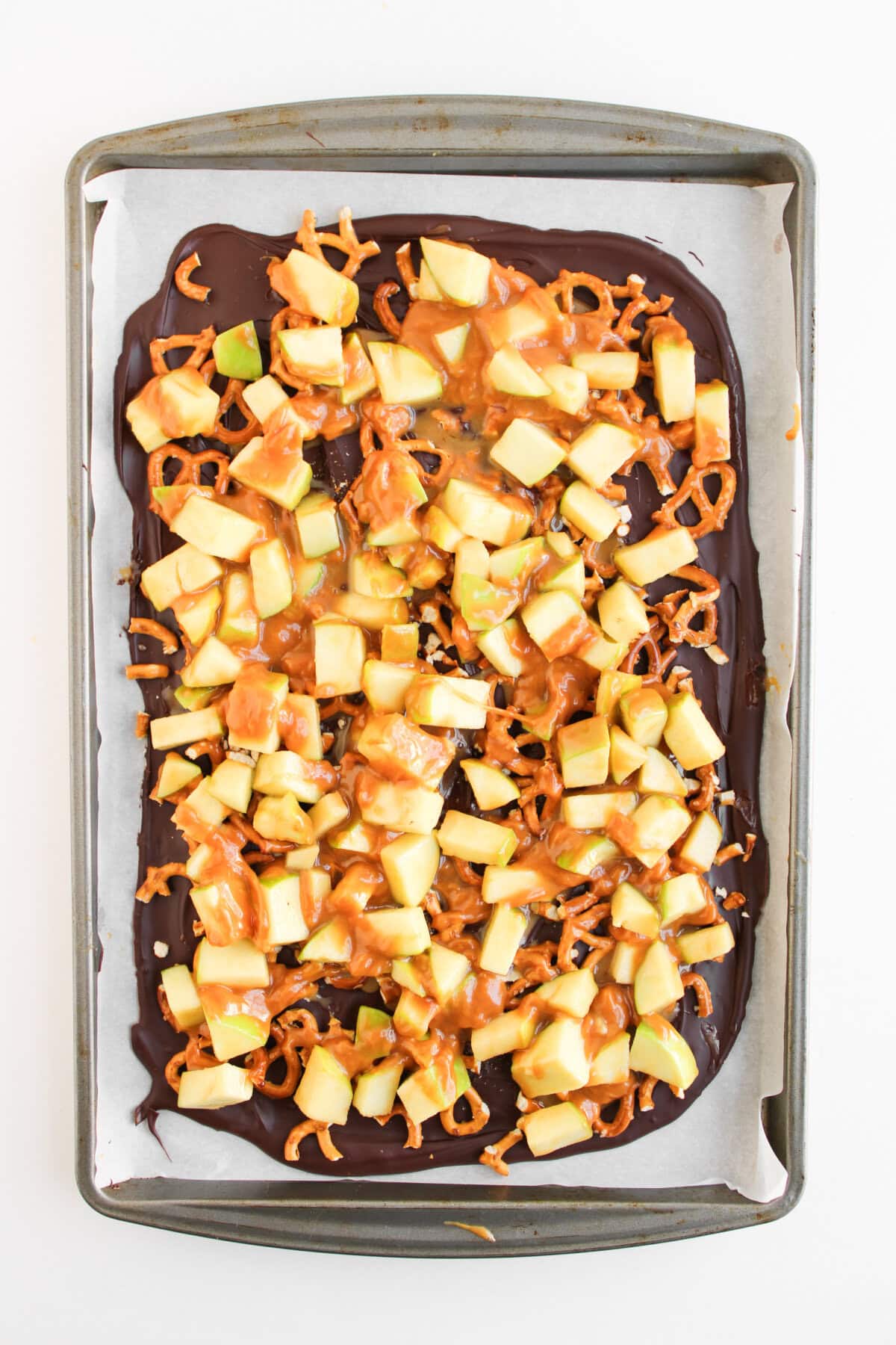 chopped apples on top of the crushed pretzels and melted chocolate.