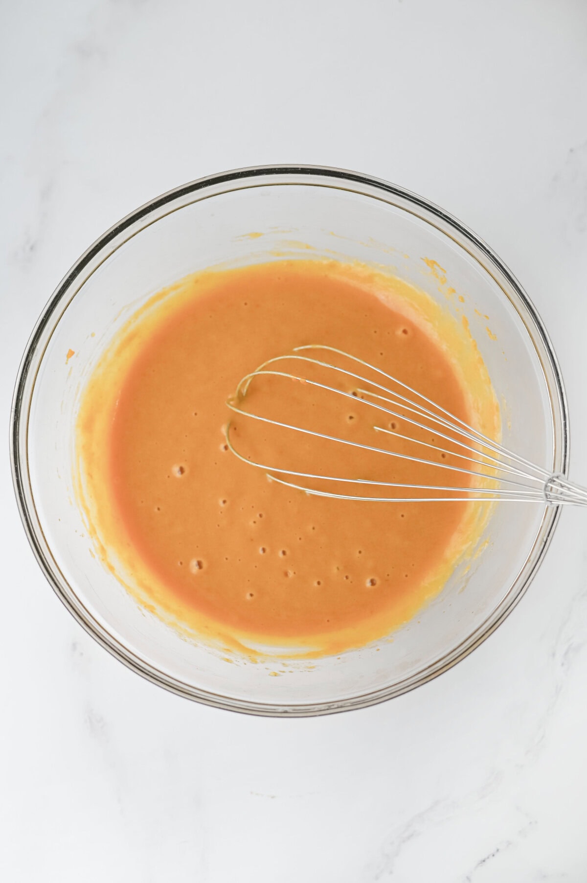 a pumpkin puree mixture whisked in a glass bowl.