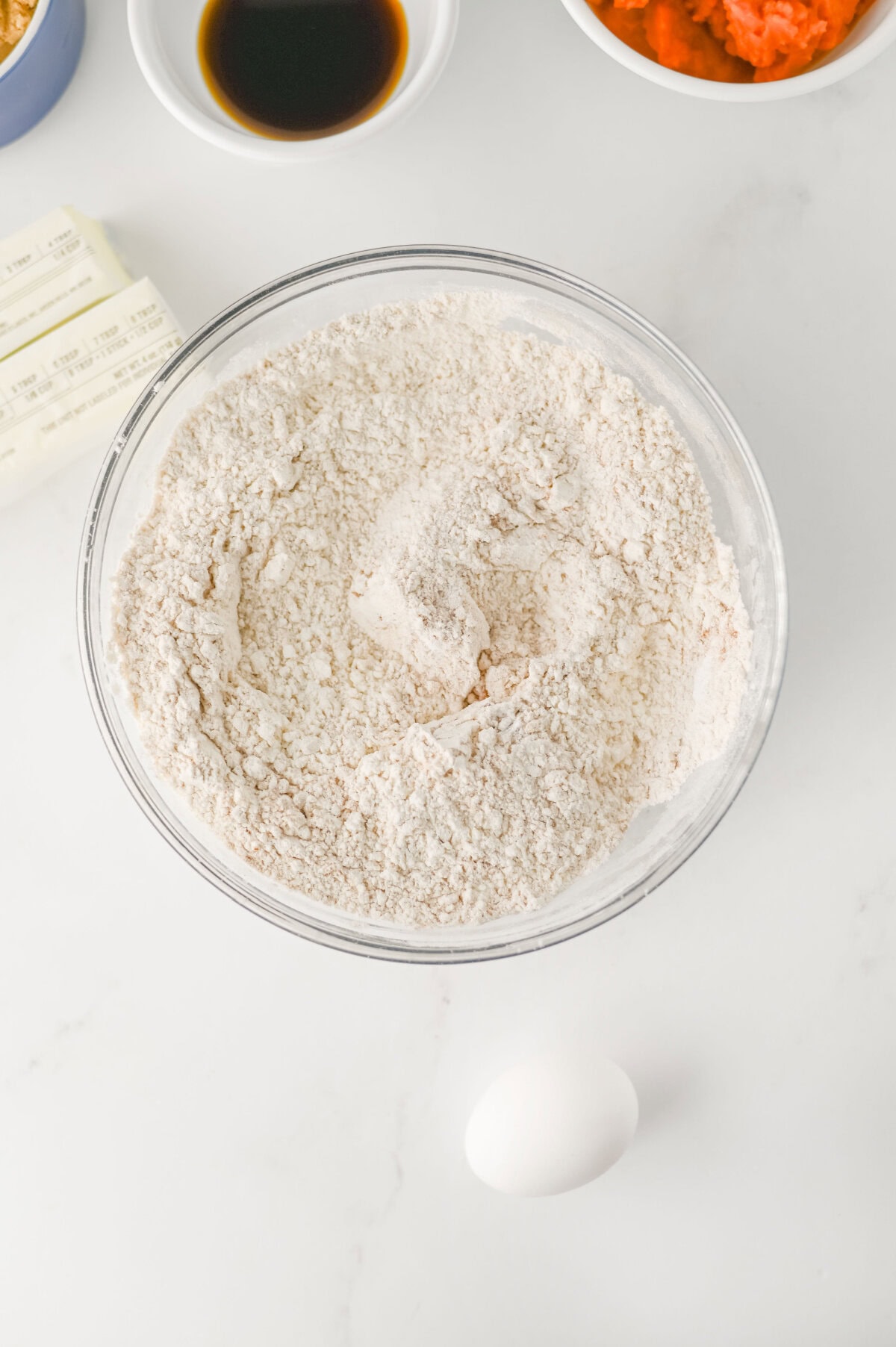 dry ingredients added to a mixing bowl to make cookies.