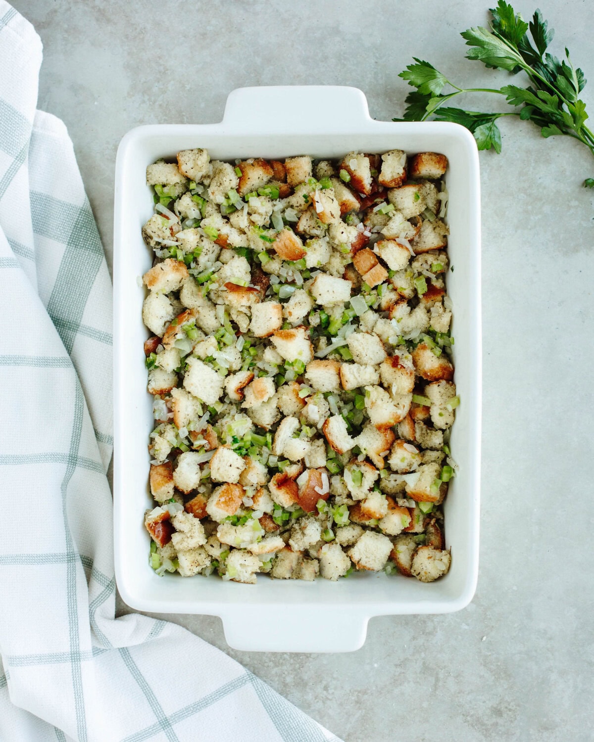 old-fashioned stuffing in a white baking dish ready to be cooked.