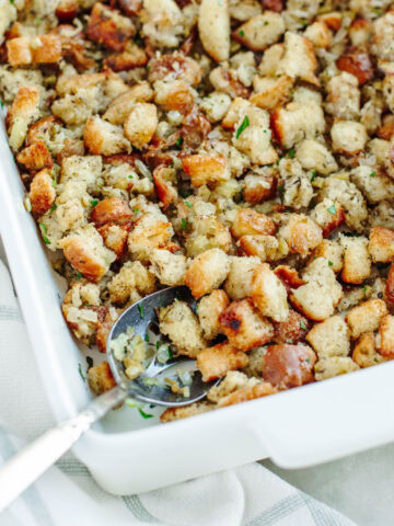 an up close look at homemade stuffing in a white baking dish ready to be served.