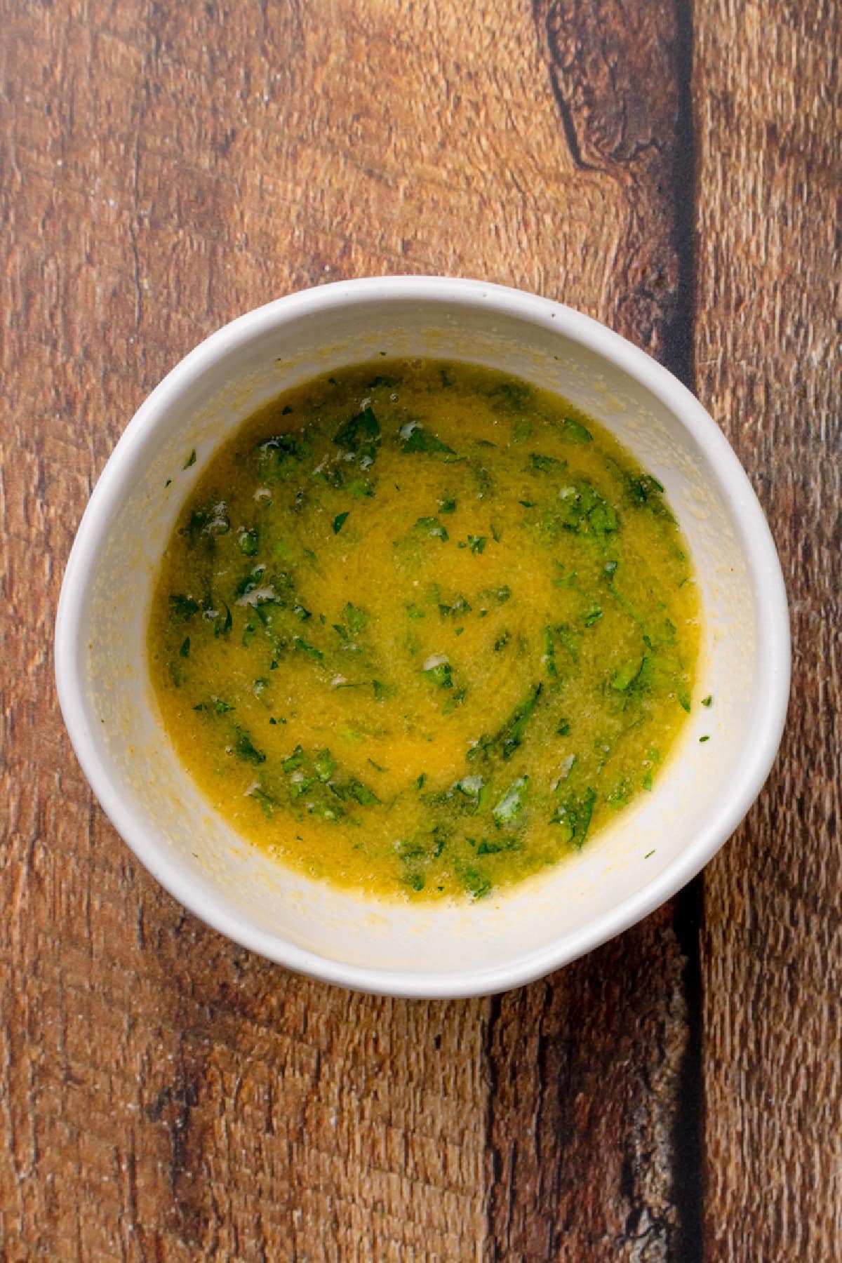butter, garlic powder, and parsley combined in a small white bowl.