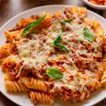 a serving of baked cheesy pasta on a white plate.