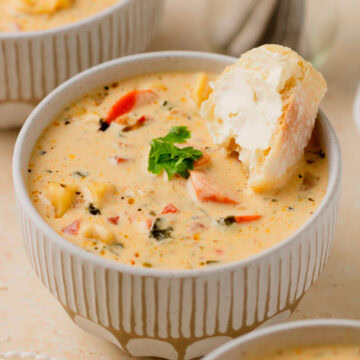 soup served in a cream soup bowl with a piece of French bread.