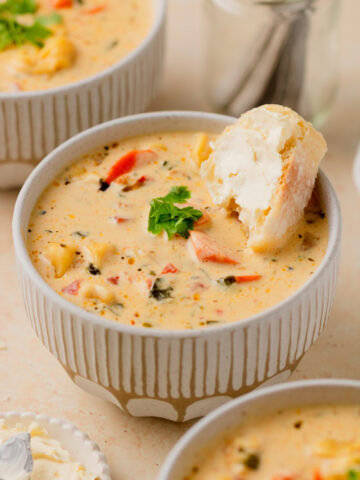 soup served in a cream soup bowl with a piece of French bread.