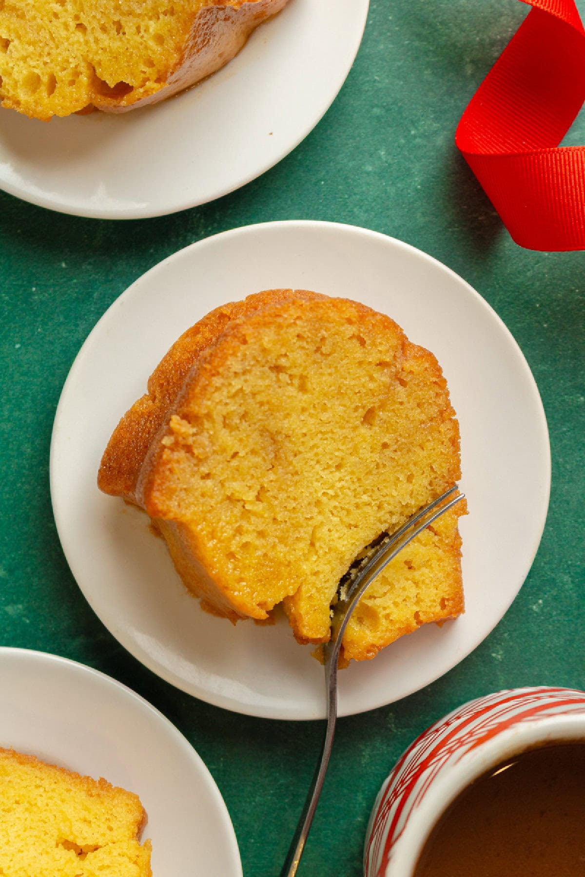 a slice of rum cake on a white plate with a fork.