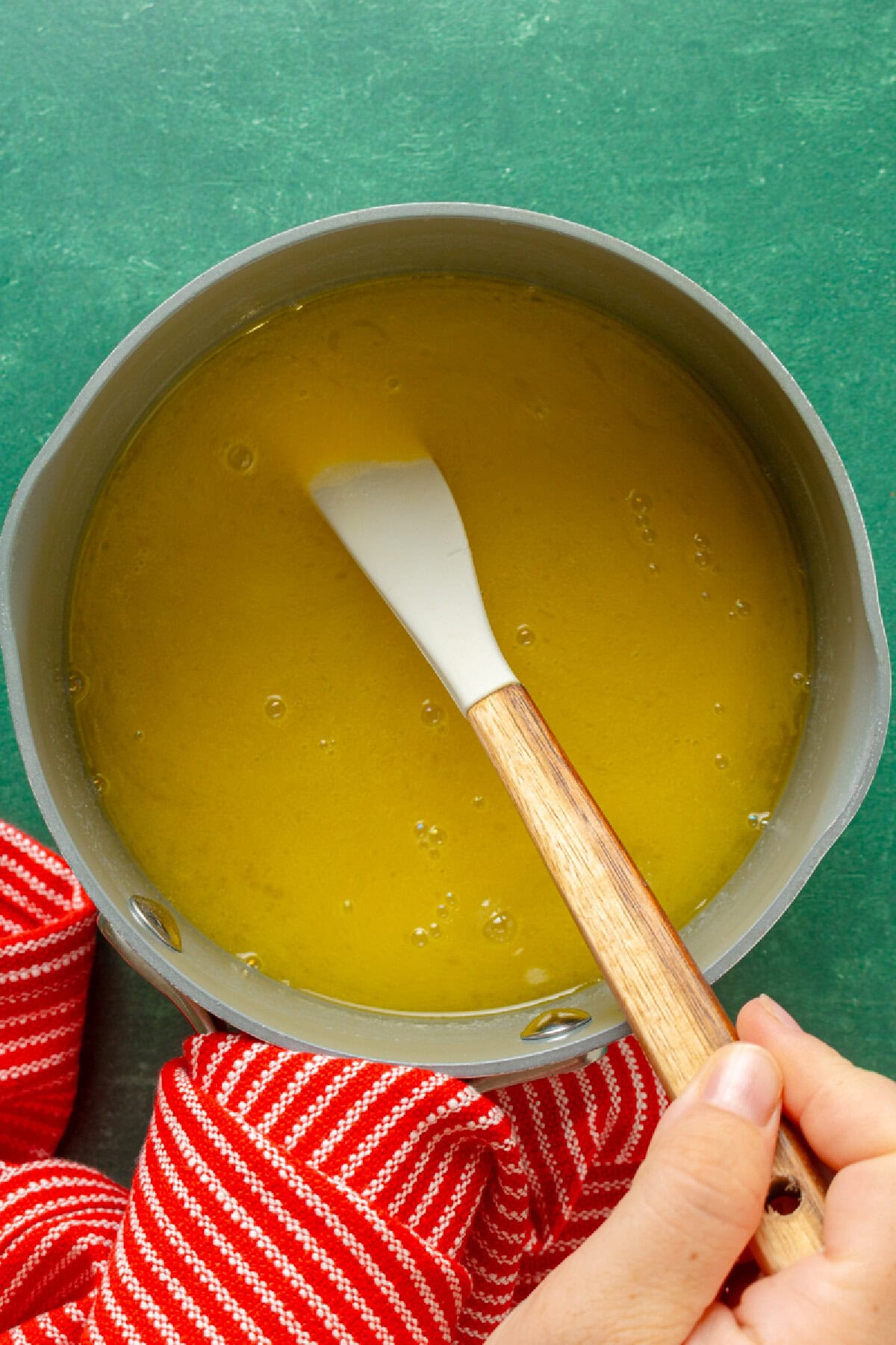 Whisking the buttery rum glaze in a saucepan.