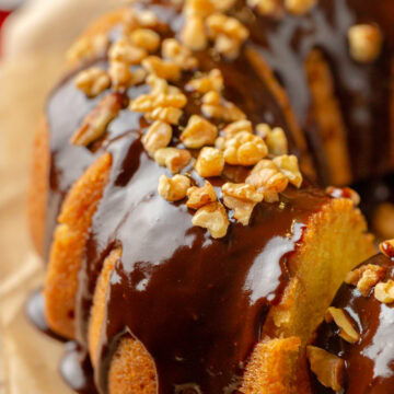 chocolate glaze drizzled on top of a rum cake with walnuts.