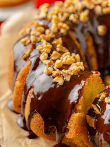 chocolate glaze drizzled on top of a rum cake with walnuts.