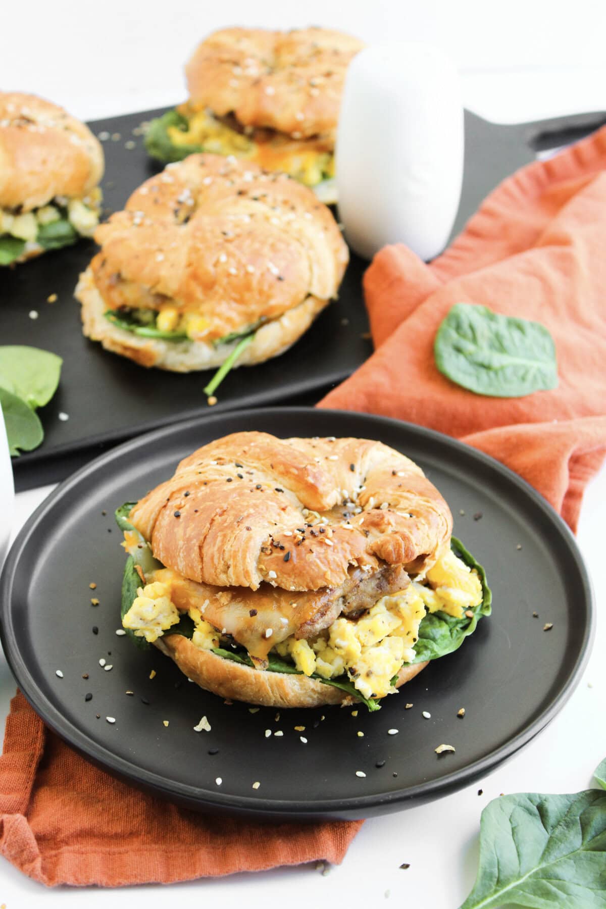 breakfast sandwiches served on black plates.