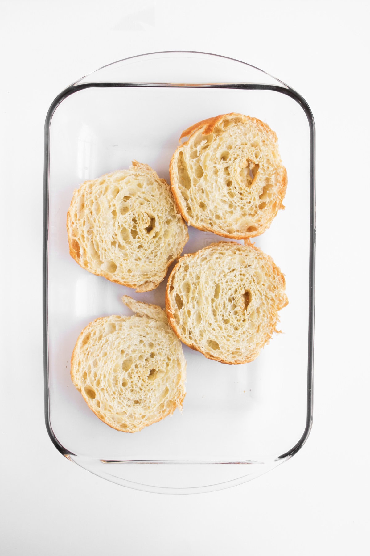 the bottom half of a croissant placed in a prepared baking dish.