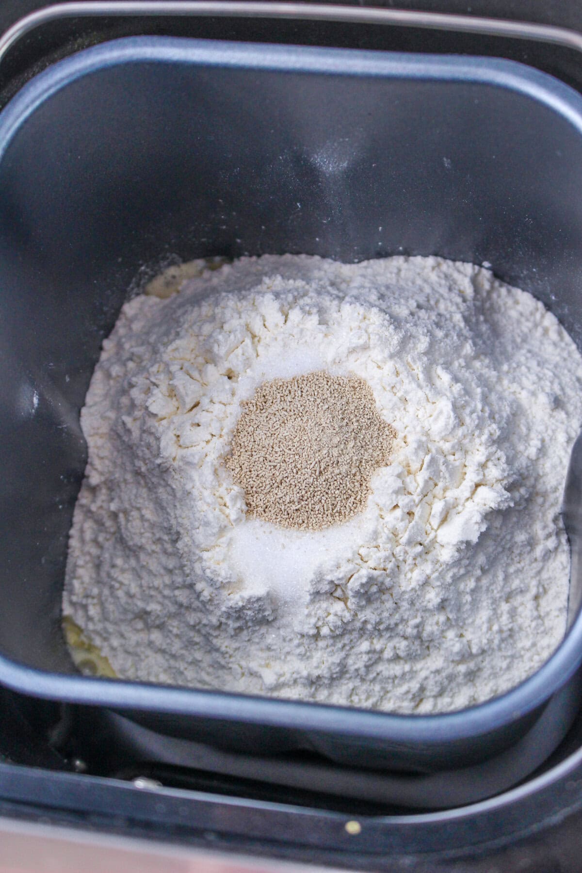 dry ingredients in a bread machine pan with active yeast in a centered well.
