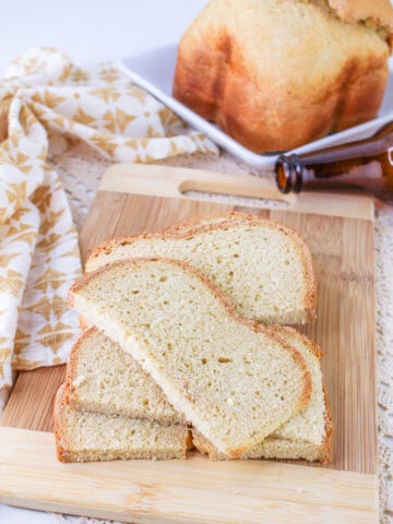 sliced bread machine beer bread on a wood cutting board.