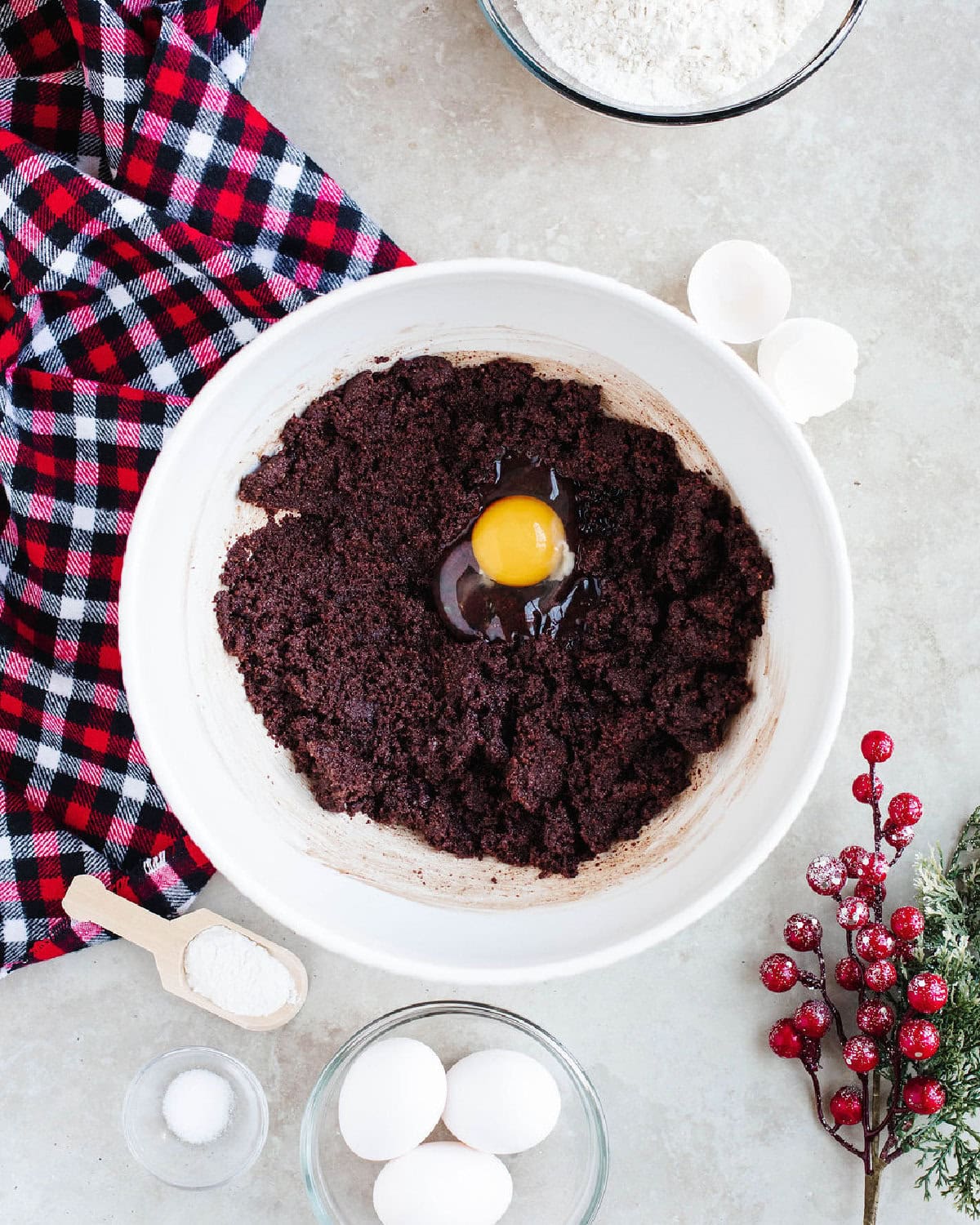 eggs added to cookie dough in a white mixing bowl.