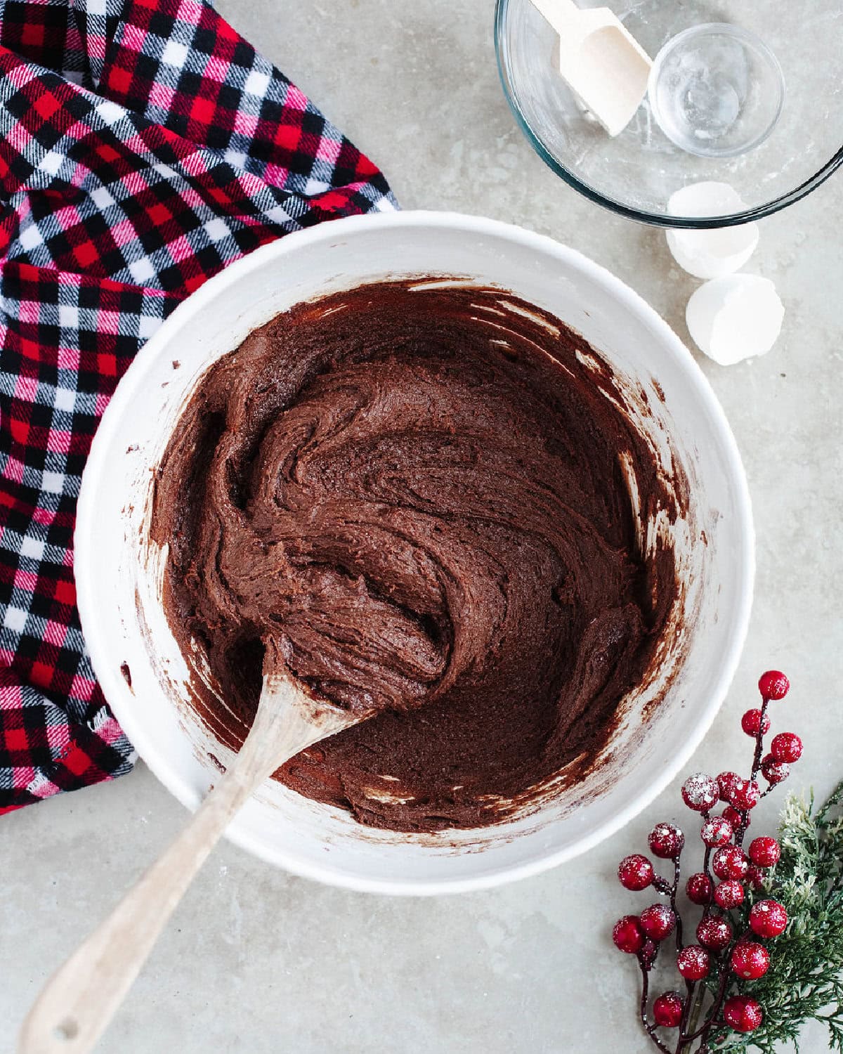 double chocolate crinkle cookie dough combined in a mixing bowl with a wood spoon.